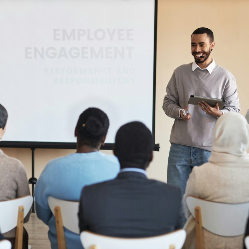 Young cheerful HR manager with tablet looking at one of employees